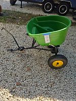 Full side view of spreader showing hopper, frame, wheels, hitch