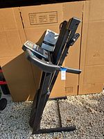 Treadmill folded upright with manual resting on console