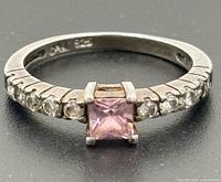 Full view of ring showing princess-cut pink centre stone and accent stones