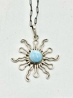 Full view of pendant on white background showing design and stone