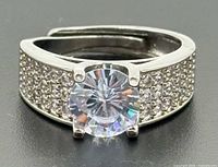 Front view showing round center stone and pave shoulders