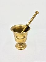 Mortar with pestle inserted standing upright