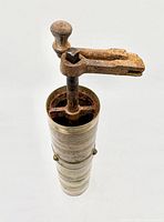 Full view of brass grinder with iron handle