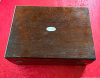 Closed rosewood box showing top surface and cartouche