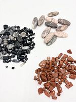 Overview of three assortments: black/gray mix, pink zebra jasper ovals, red-brown goldstone shapes