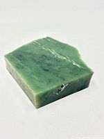 Top view of green nephrite jade block showing cut surface and inclusions