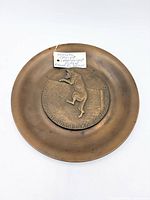 Front view of bronze plaque showing dog relief and inscription