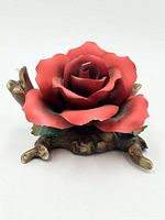 Front view of red rose figurine on branch