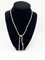 Necklace displayed on bust form highlighting pearl size and clasp