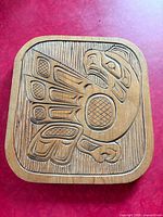 Front view of carved cedar plaque depicting eagle