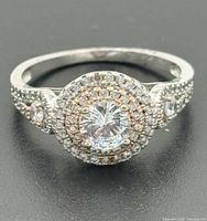 Front view showing double-halo, center stone, two-tone detail