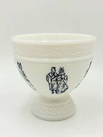 Front view of milk glass pedestal bowl showing blue figure motif and pedestal base