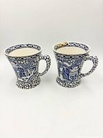 Front view of two mugs showing chinoiserie design and flared shape