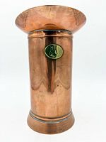 Front view showing copper body, brass medallion and base