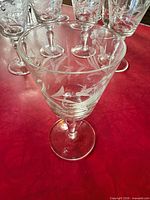 Front view of one crystal stem glass with etched design, others behind