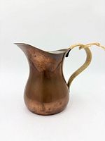 Side view of hammered copper jug showing shape and handle