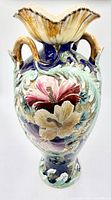 Full front view of porcelain vase showing floral relief and handles