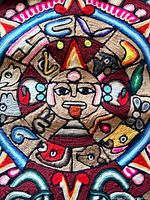 Close-up of central embroidered Tonatiuh face and surrounding glyphs