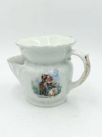 Front view showing courting scene decal, handle, spout, gold trim