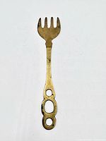 Front view of entire brass serving fork