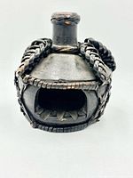 Front view showing rectangular cavity, rattan wrapping and overall shape