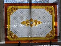 Full view of stained glass panel showing borders, lattice field, and central motif