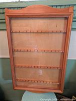 Front view showing full rack, glass panel, wood frame, spoon slot rows