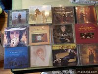 12 CD jewel cases laid out, all titles visible