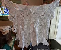 Full view of lace panel held up, showing overall size and pattern
