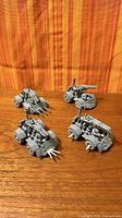 Four assembled grey plastic Ork Battle Fortress vehicles on wood surface