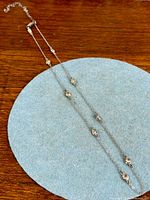 Full view of sterling silver station necklace laid flat showing overall length and spacing of stones
