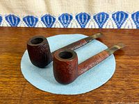 Two Savinelli pipes side by side on blue mat