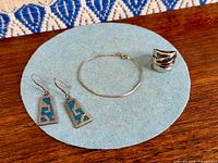 All three jewellery pieces on felt pad: earrings, bracelet, ring