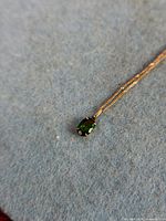 Close-up of pendant showing green tourmaline set in 9 kt gold on chain