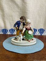 Front view of figurine showing children and cat