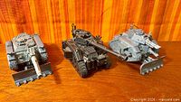 Front view of three assembled Leman Russ tanks with dozer blades and turret cannons