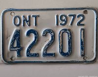 Front view of 1972 Ontario motorcycle plate 42201 showing full design and wear