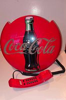 Front view showing Coca-Cola graphics and handset in cradle