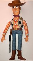 Front view of large Woody talking doll with hat, vest, jeans, boots and Sharpie for scale