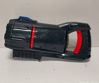 Side profile of projector launcher showing body, grip, speaker grille and controls