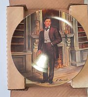 Front view of porcelain collector plate in shipping box showing artwork, signature, and condition