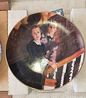 Front view of porcelain collector plate showing illustration and gilt rim