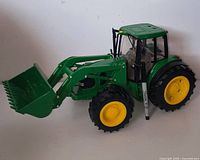 Left side view of tractor showing loader and bucket