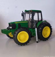 Left side view of John Deere 7330 1:16 scale tractor with marker for size reference