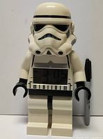 Front view of LEGO Star Wars Stormtrooper digital alarm clock standing beside Sharpie for scale