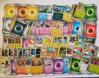 Spread of assorted Pokémon, Energy and Trainer cards displayed flat