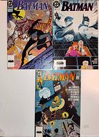 Front covers of three Batman comic books laid out together