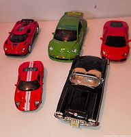 Five die-cast model cars displayed on surface
