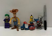 Front view of four minifigures and scooter with Sharpie for scale