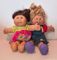 Front view of both Cabbage Patch Kids dolls showing hair, outfits, and condition